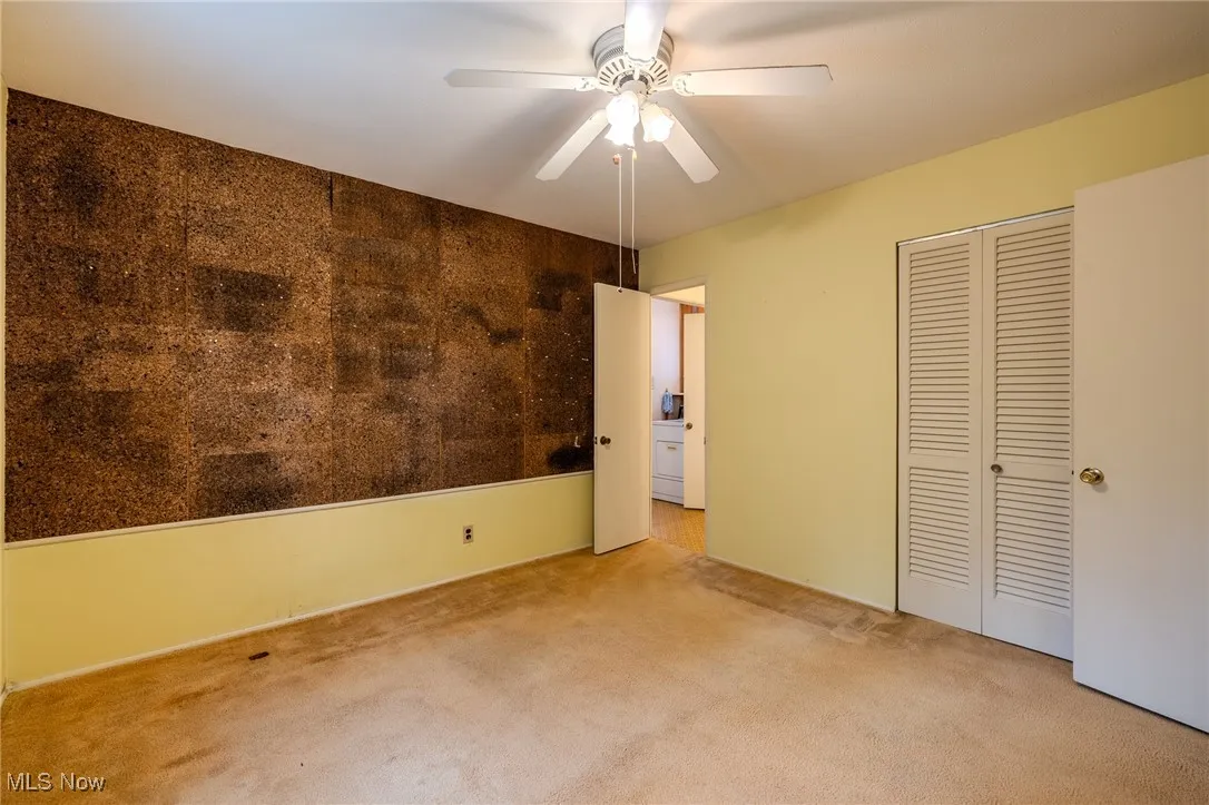 Unfurnished bedroom featuring carpet, a closet, and ceiling fan