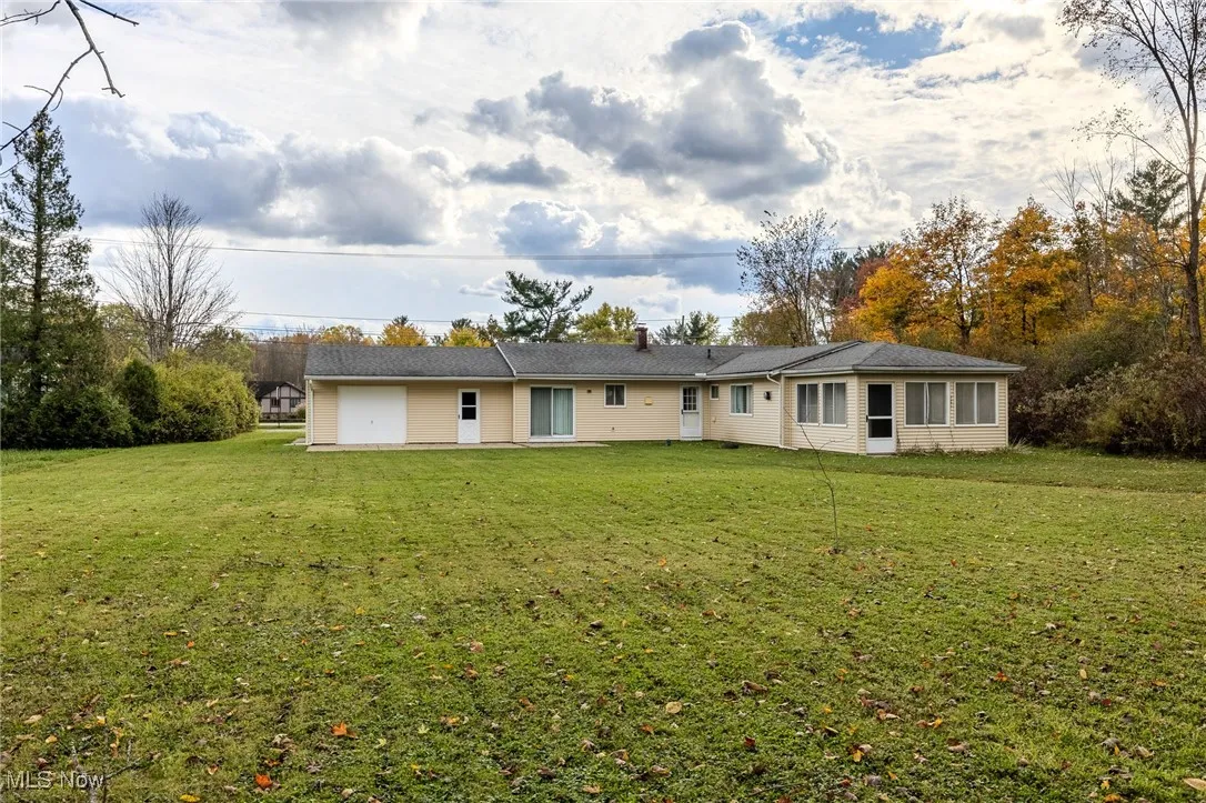 Back of house featuring a lawn and a chimney