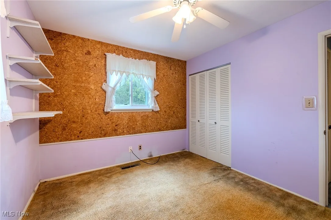 Unfurnished bedroom with a closet, carpet floors, and a ceiling fan