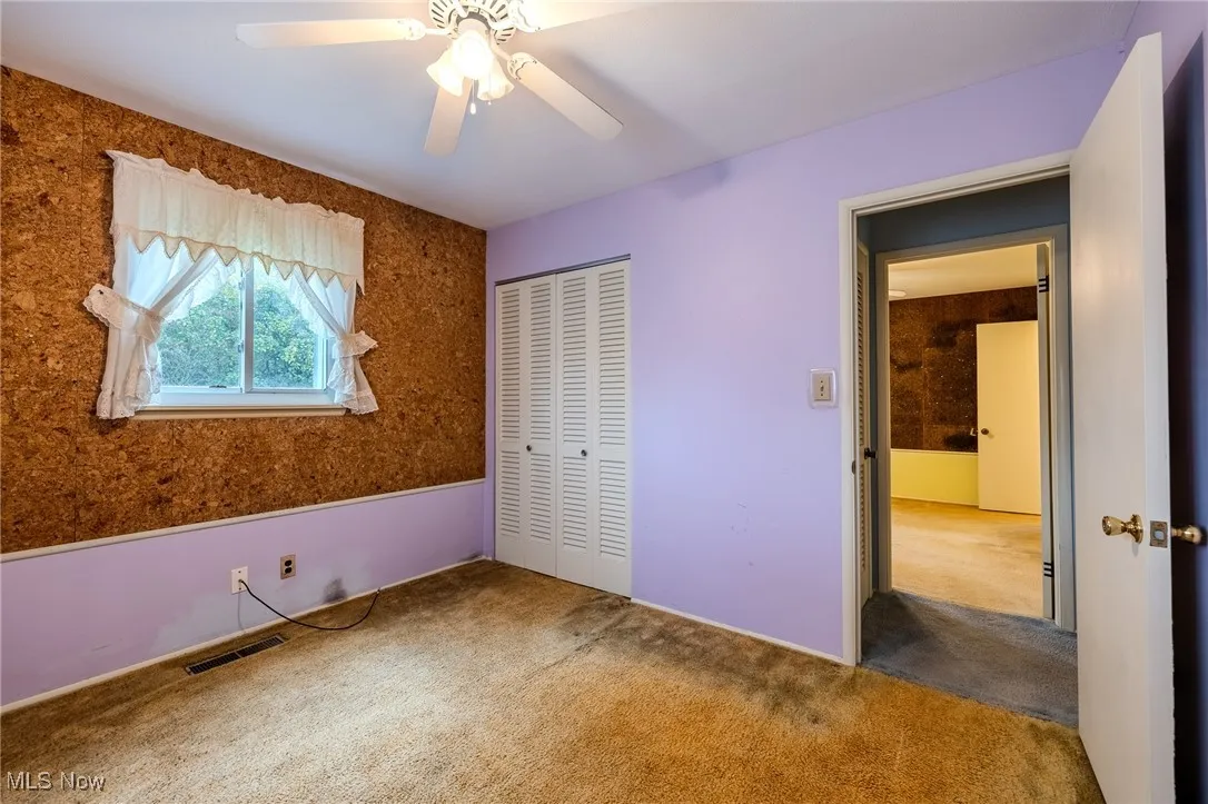Unfurnished bedroom featuring carpet floors, a ceiling fan, and a closet