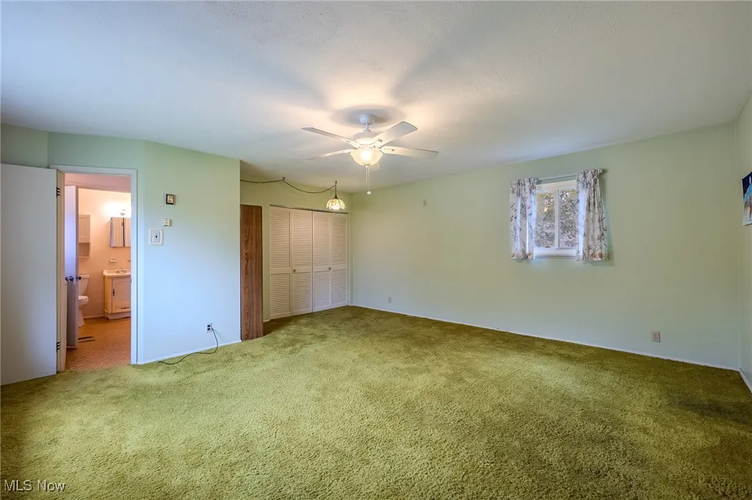 Unfurnished bedroom with a closet, carpet floors, and a ceiling fan
