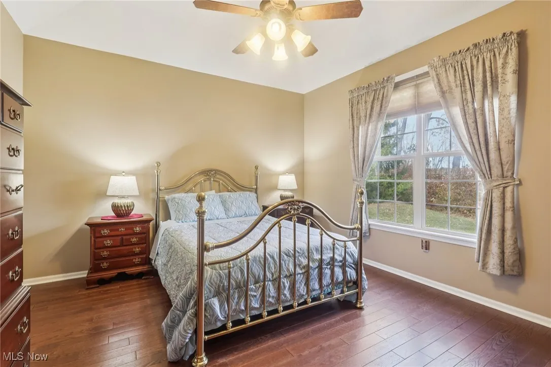 Bedroom with dark wood-style flooring and a ceiling fan