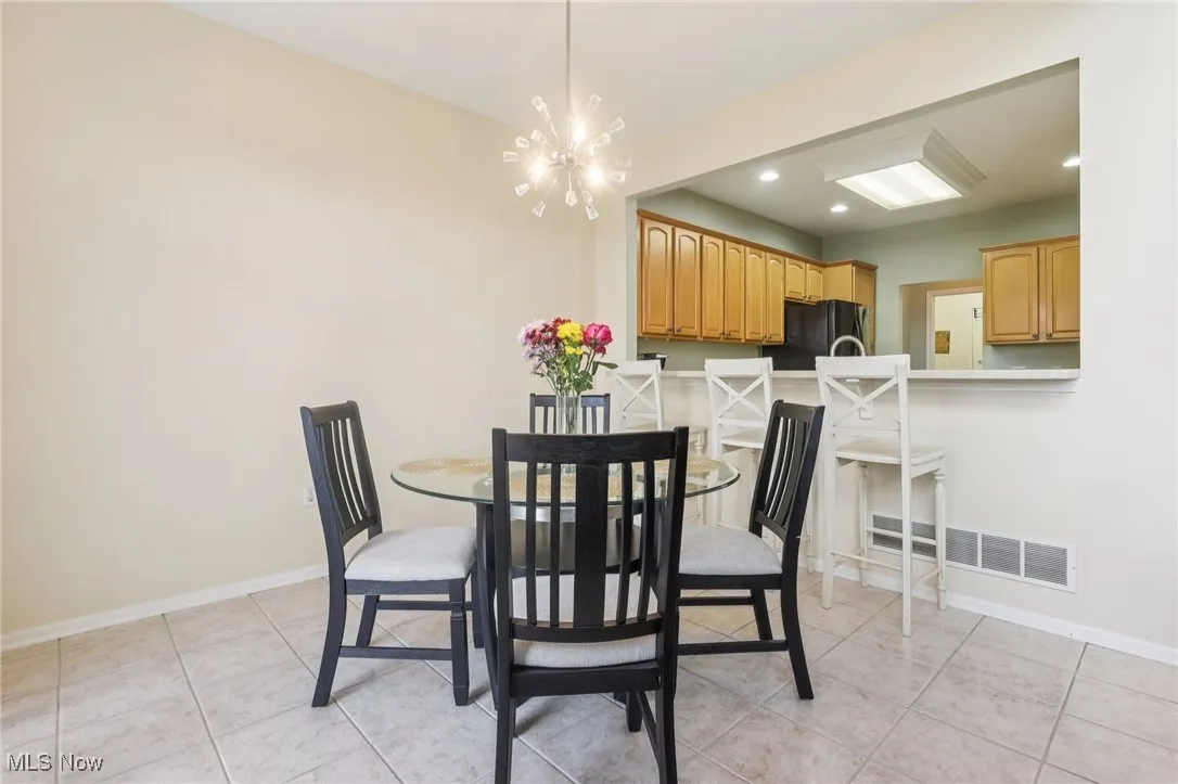 Dining room with recessed lighting, light tile patterned flooring, and a chandelier