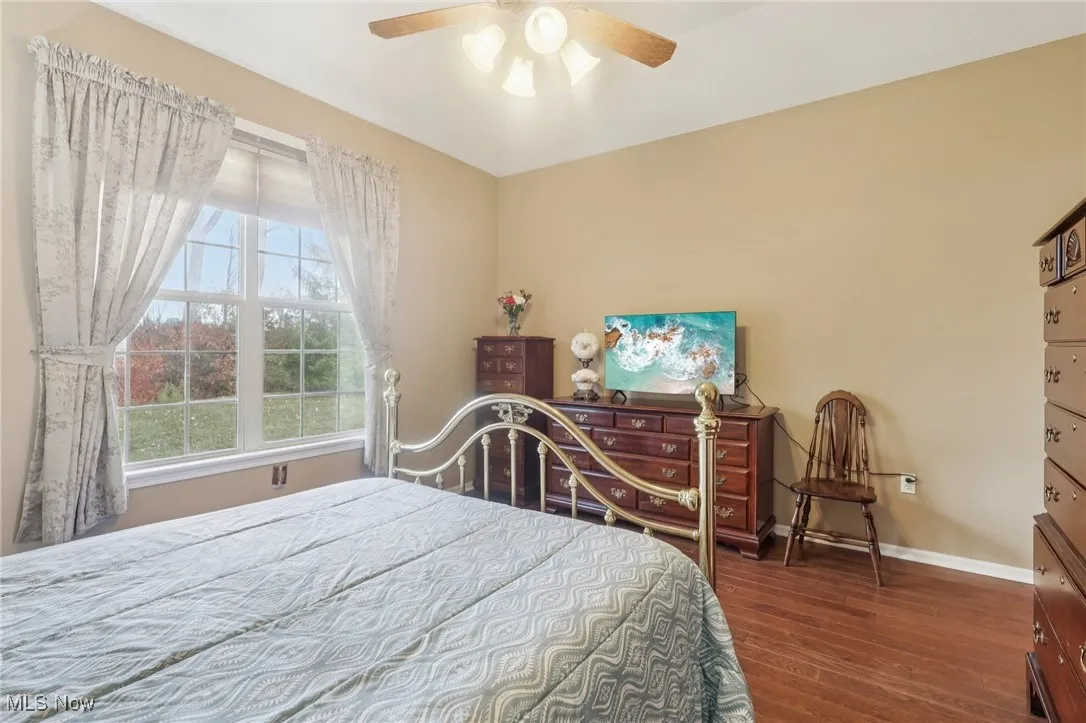 Bedroom with dark wood-style flooring and ceiling fan