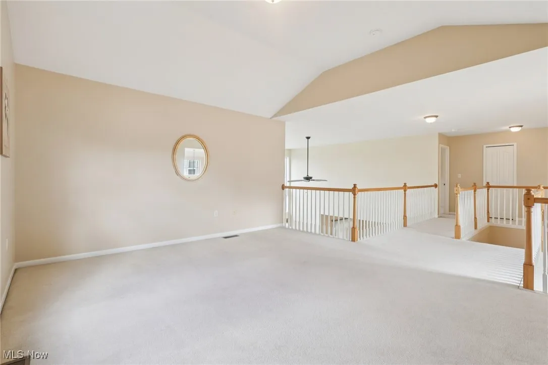 Unfurnished room featuring vaulted ceiling, carpet floors, and ceiling fan