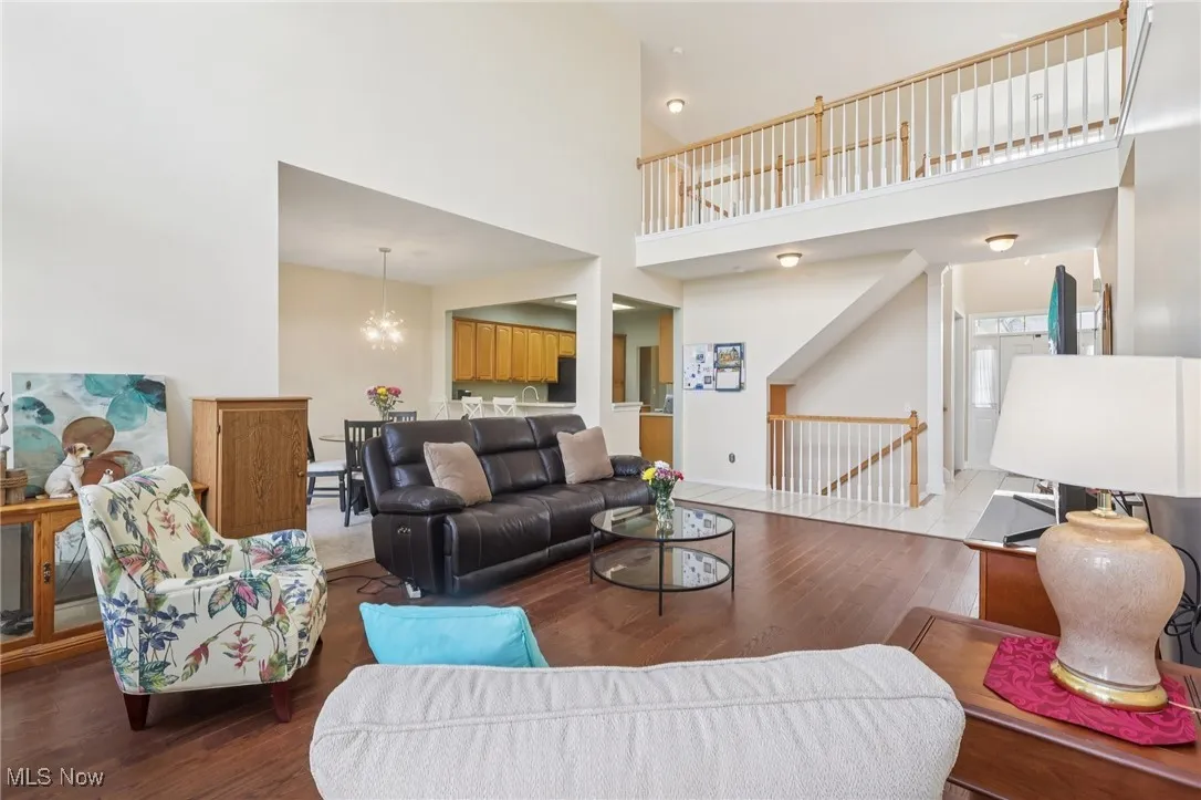 Living area featuring wood finished floors, a high ceiling, and a chandelier