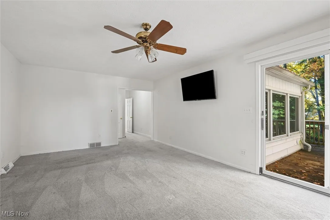 Carpeted Master bedroom with a ceiling fan and baseboards