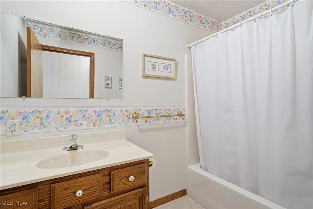 Full bathroom featuring vanity and shower / bath combo with shower curtain