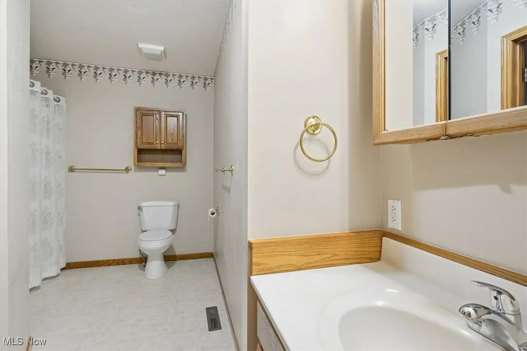 Full bath with vanity, a shower with curtain, and light flooring
