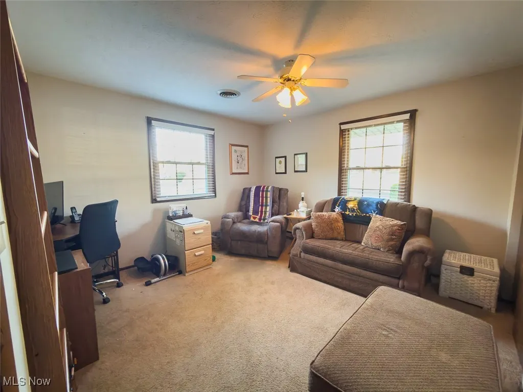 Carpeted office with ceiling fan