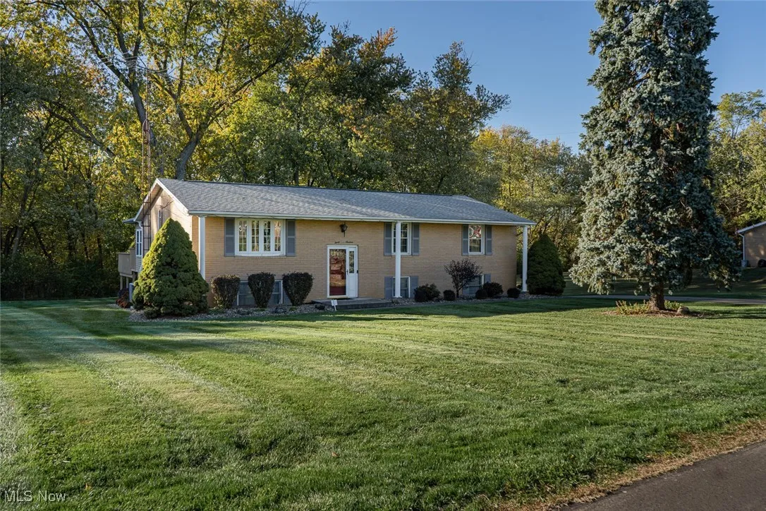 Split foyer home with a front lawn and brick siding
