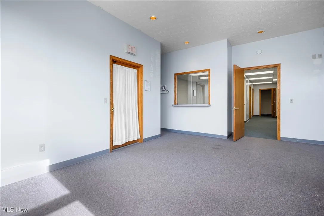 Carpeted empty room with baseboards and a textured ceiling