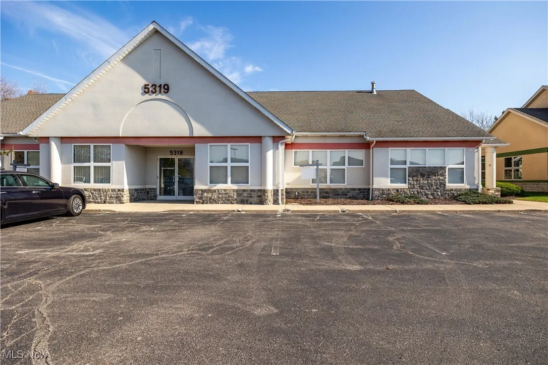 View of building exterior with uncovered parking