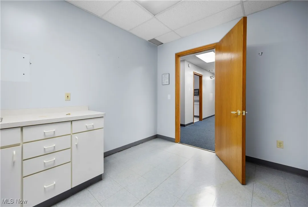 Empty room featuring a drop ceiling and light flooring