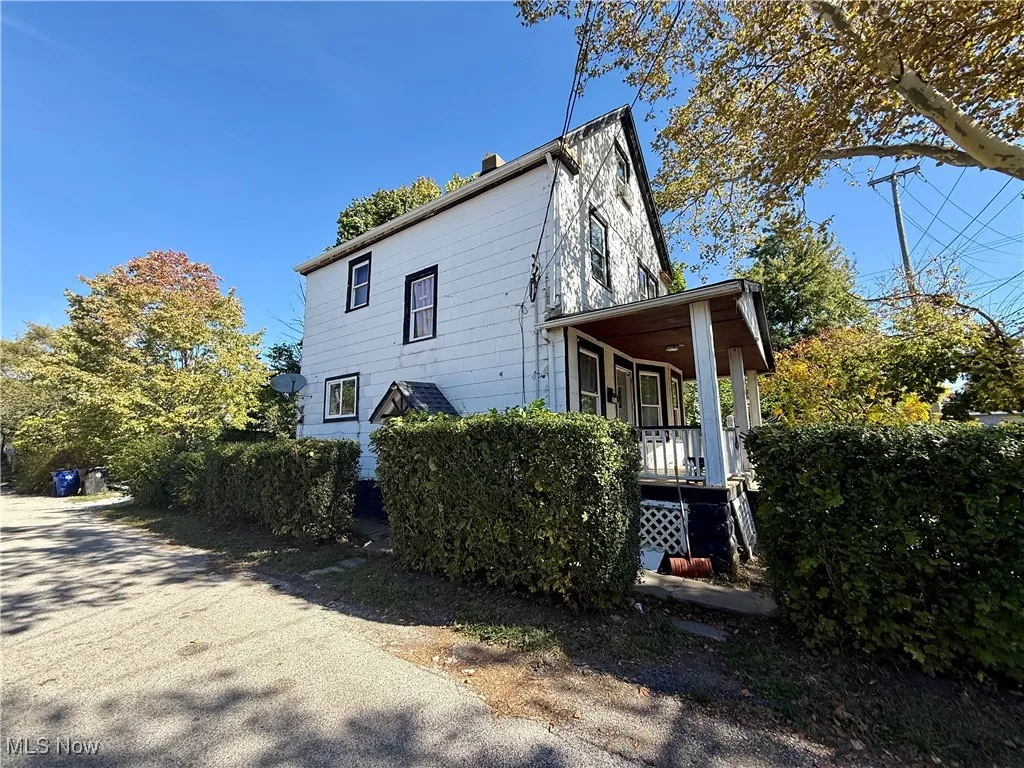 View of home's exterior featuring covered porch and a chimney