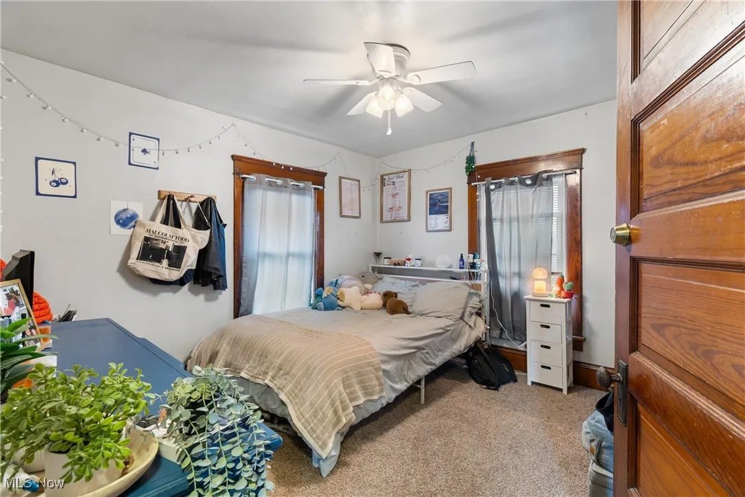 Carpeted bedroom featuring a ceiling fan