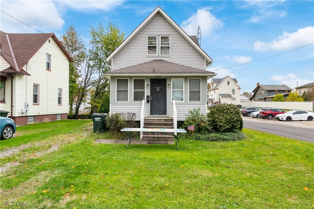View of front of home with a front lawn and roof with shingles