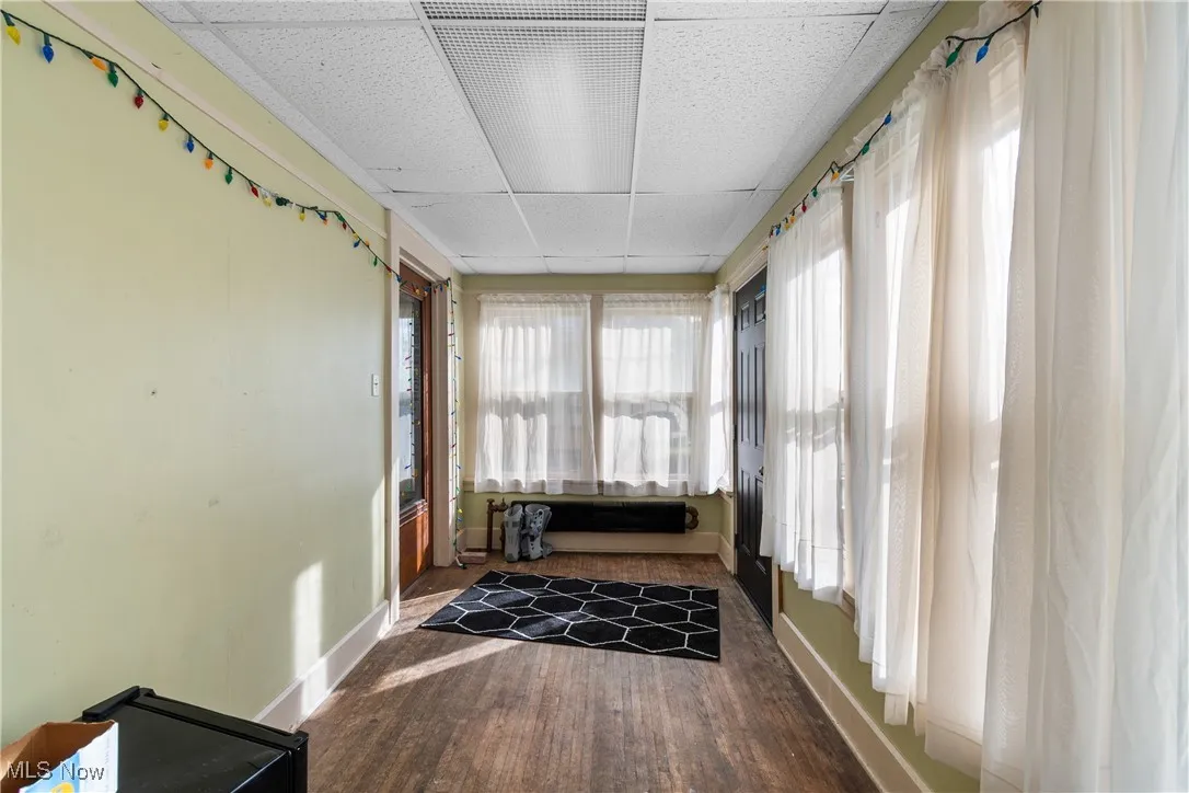 Sunroom with wood finished floors and a drop ceiling
