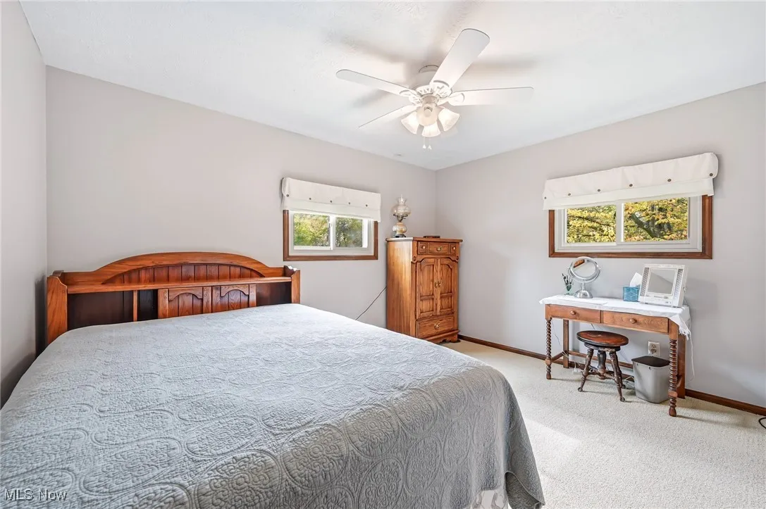 Carpeted bedroom with baseboards and a ceiling fan