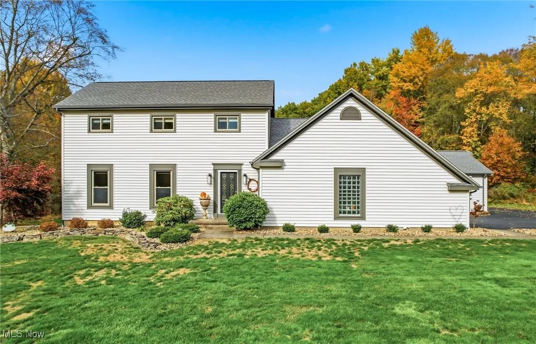 View of front of home featuring a front yard and a shingled roof