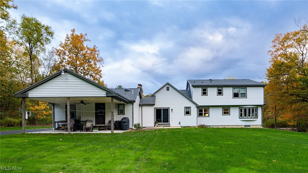 Rear view of house featuring ceiling fan, a patio, a yard, and entry steps