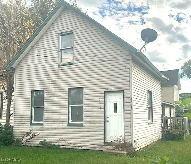 Back of property with a yard and a wooden deck