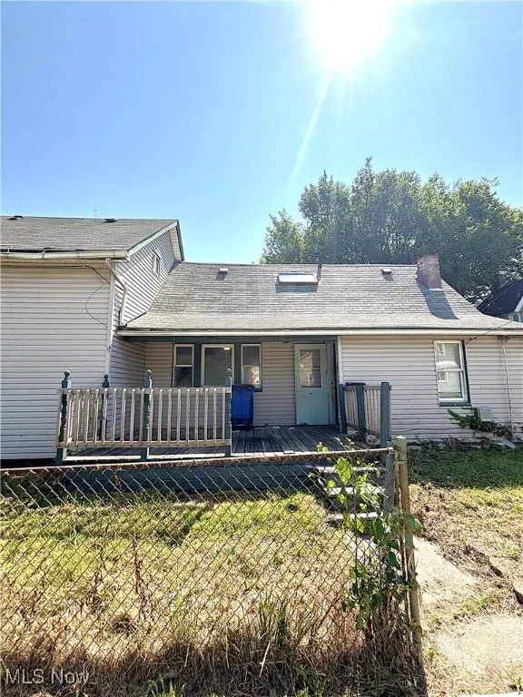 Rear view of house featuring a wooden deck and a shingled roof