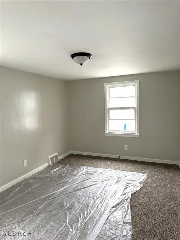 Unfurnished room with baseboards and carpet floors