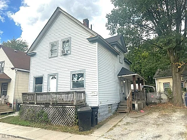 View of front of home with a chimney and a wooden deck