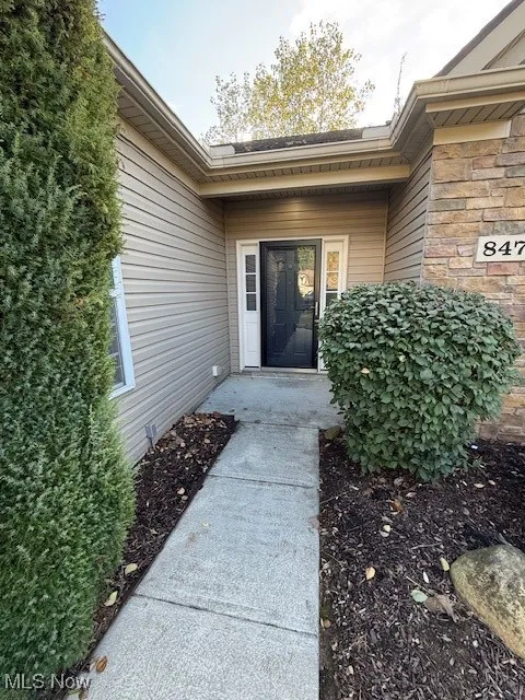 Entrance to property featuring stone siding