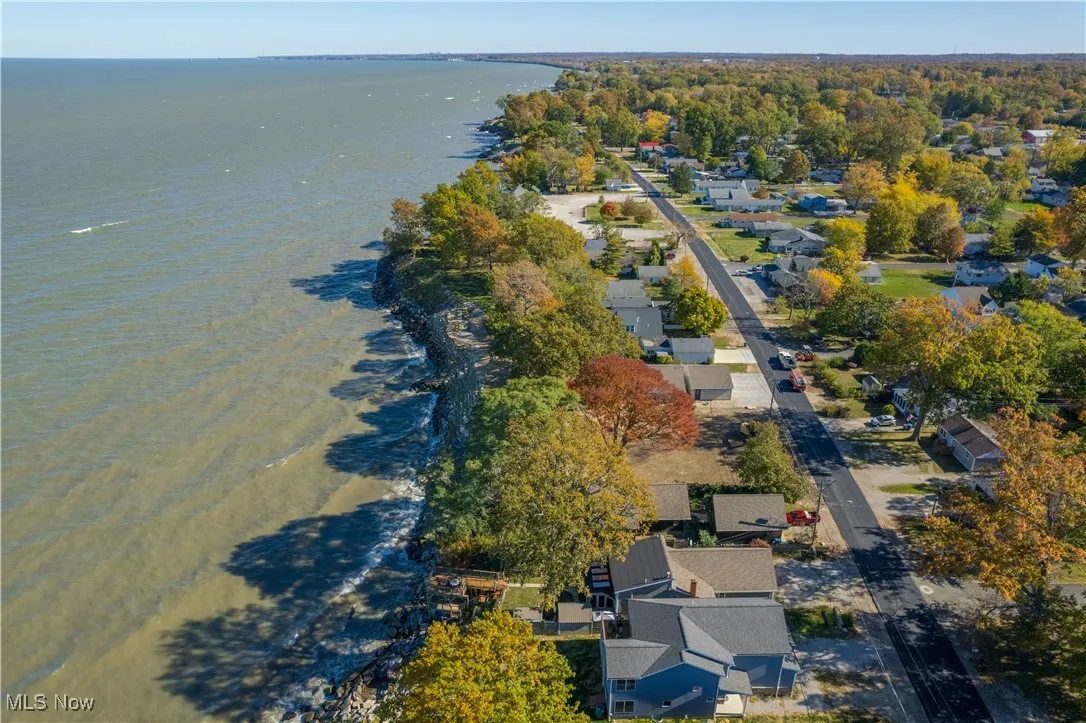 Aerial view of property's location featuring a nearby body of water and nearby suburban area