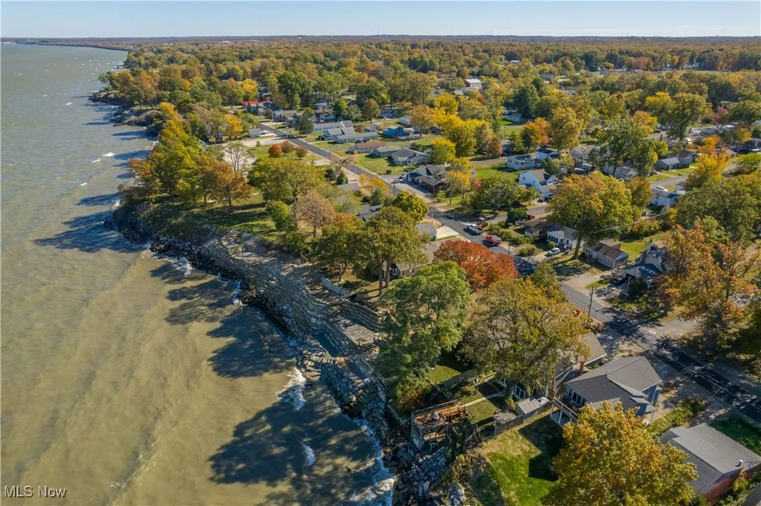 Aerial view of property's location featuring a nearby body of water and nearby suburban area