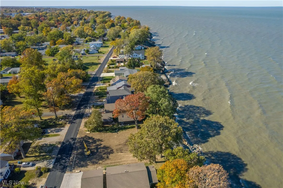 Aerial view of property and surrounding area with a large body of water and nearby suburban area