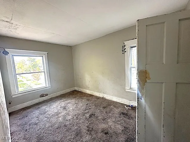 Empty room featuring baseboards and carpet floors