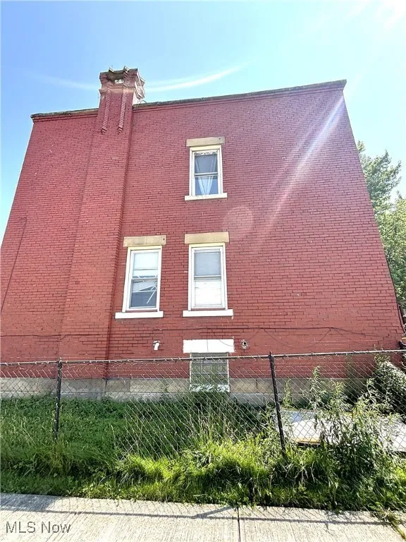View of home's exterior with brick siding and a chimney