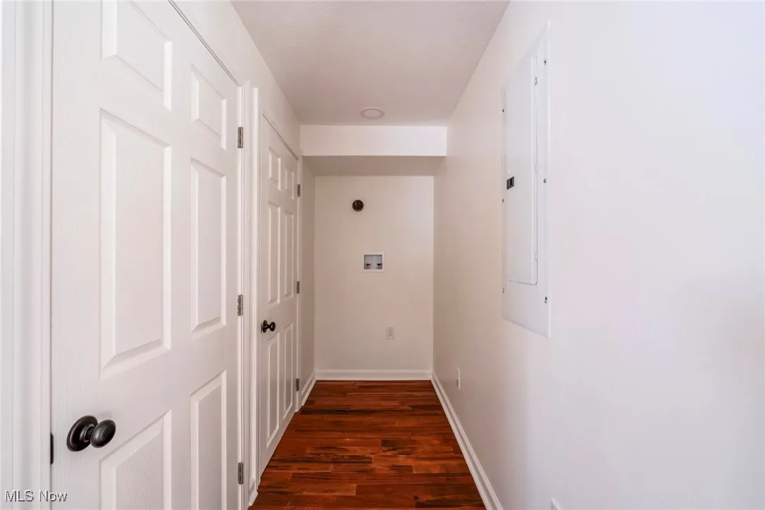 Corridor with dark wood-style flooring and electric panel