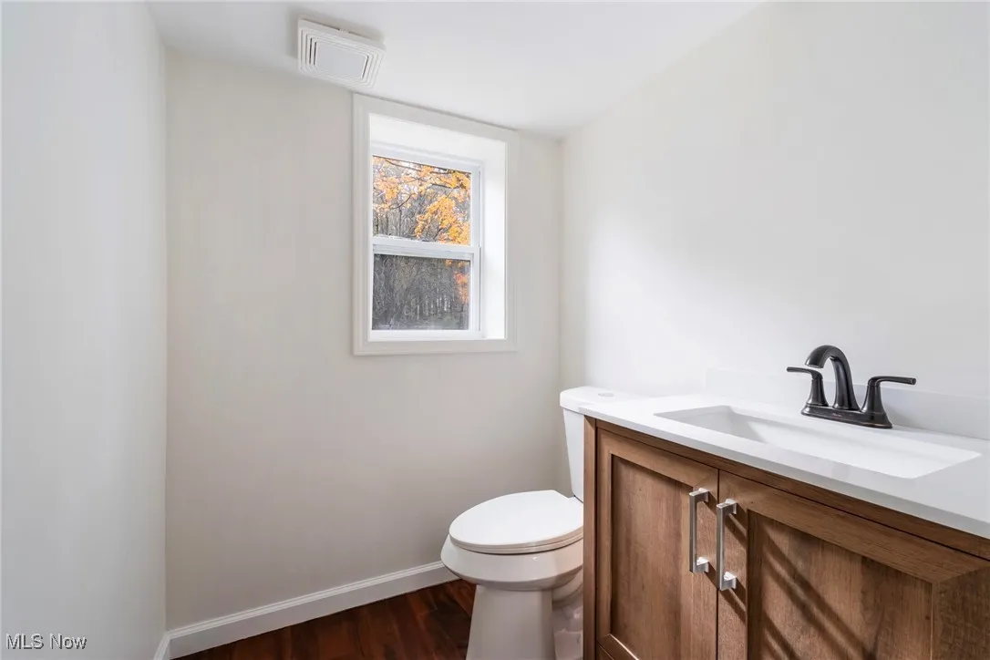 Half bathroom featuring dark wood finished floors and vanity