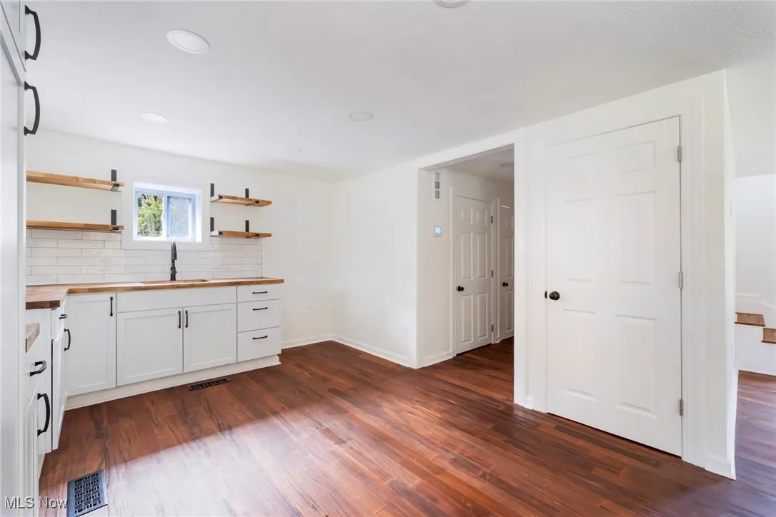 Kitchen featuring white cabinetry, backsplash, open shelves, dark wood-style floors, and recessed lighting