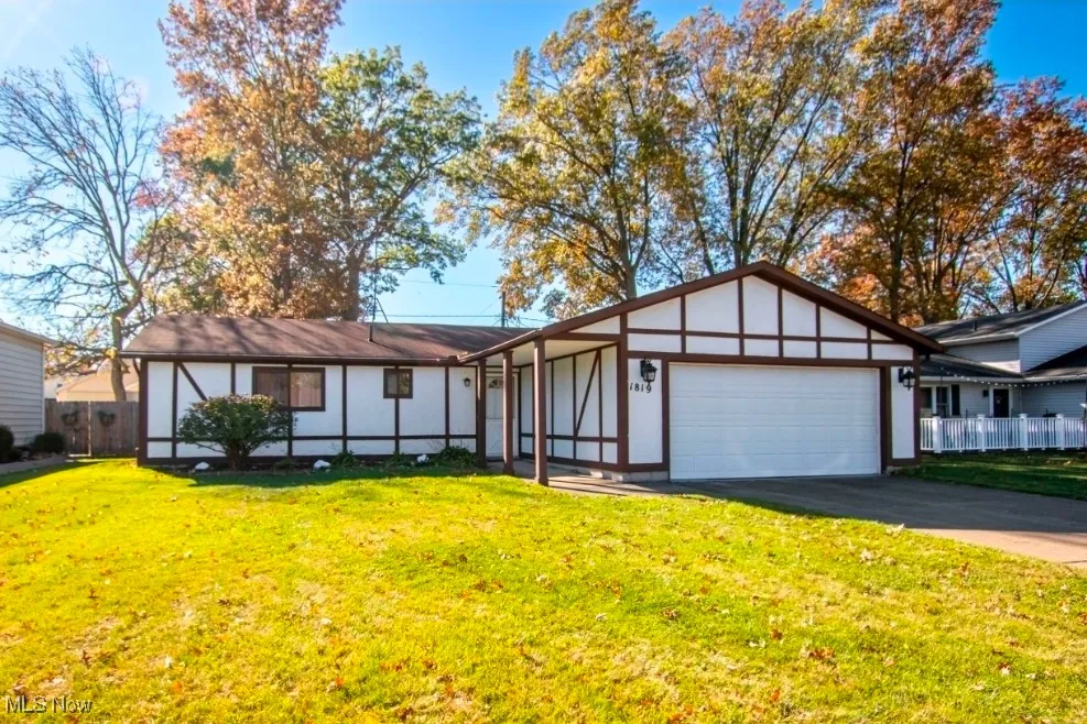 Single Story Ranch style home with driveway, an attached garage, and stucco - wood siding