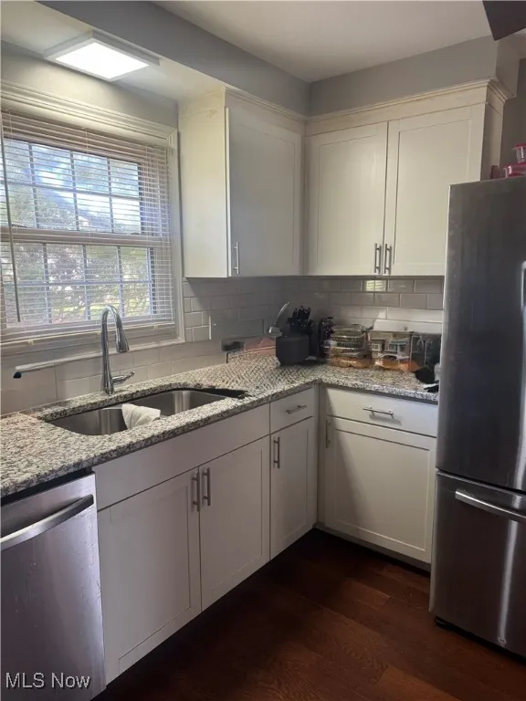 Kitchen featuring white cabinets, light stone countertops, and appliances with stainless steel finishes