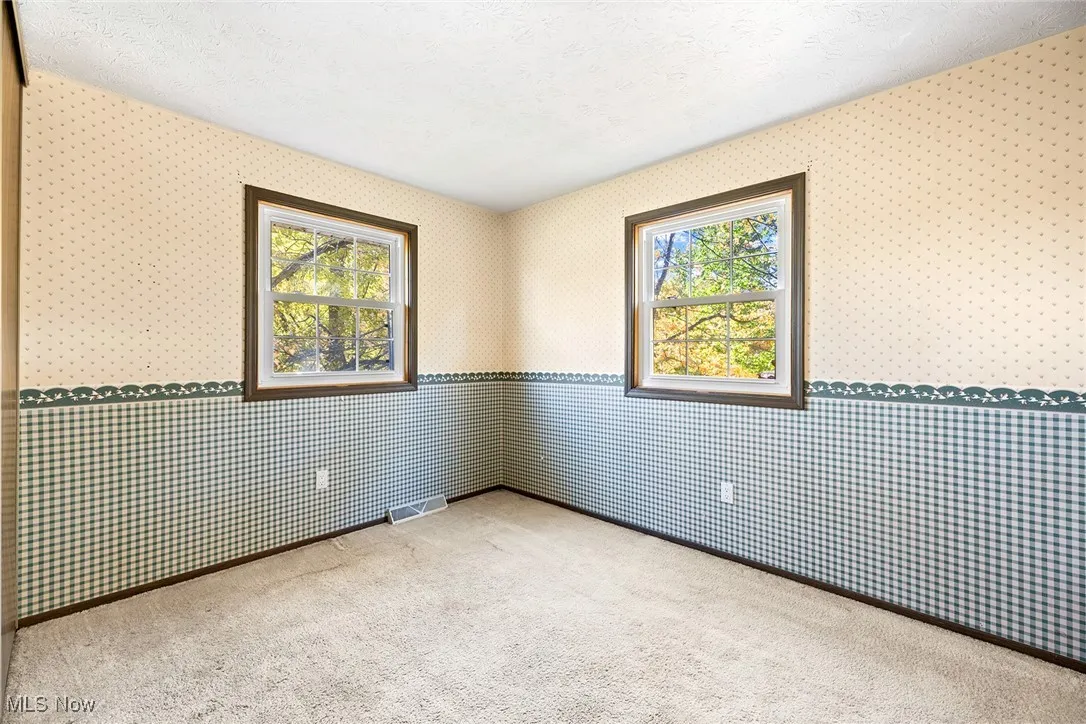 Carpeted spare room featuring a textured ceiling