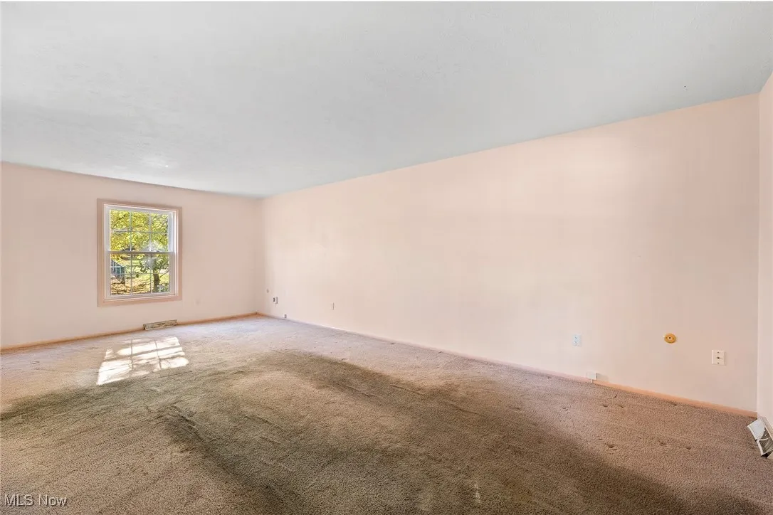 Carpeted empty room featuring baseboards