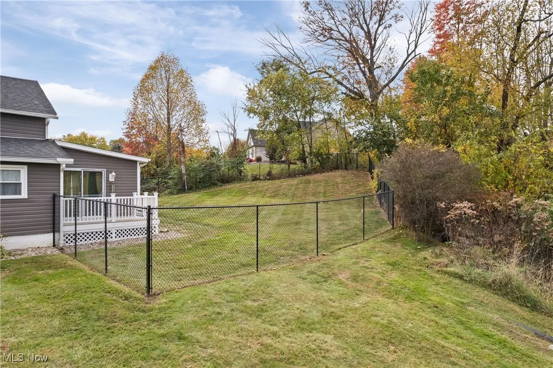 View of yard featuring a wooden deck and view of wooded area