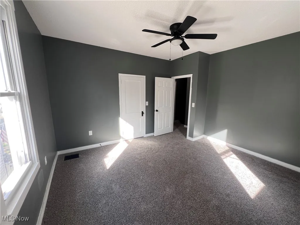 Unfurnished bedroom with carpet floors and a ceiling fan