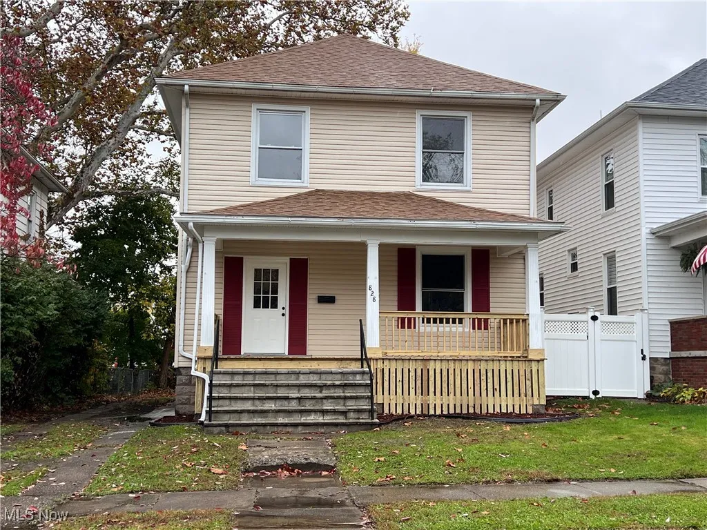 American foursquare style home with covered porch and roof with shingles