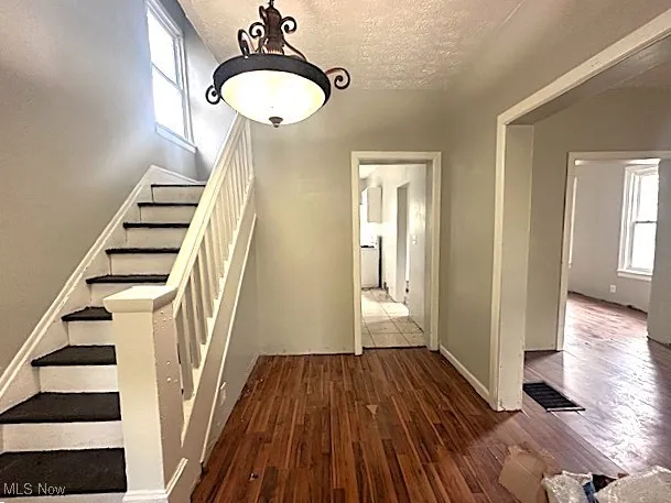 Staircase with a textured ceiling and wood finished floors
