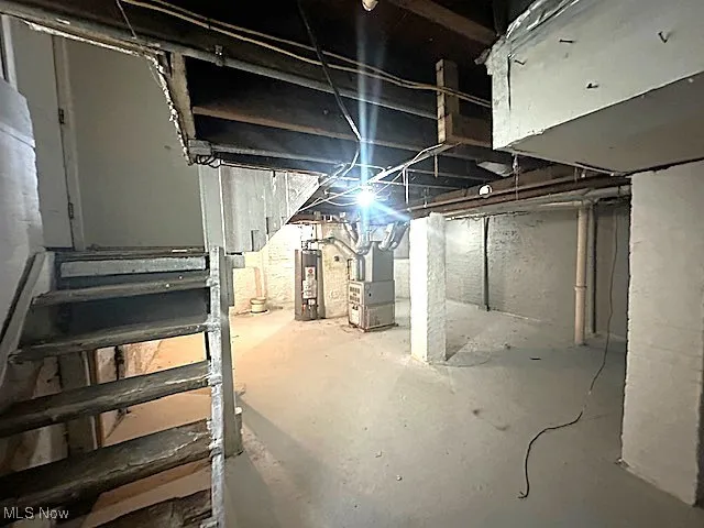 Unfinished basement with heating unit and water heater