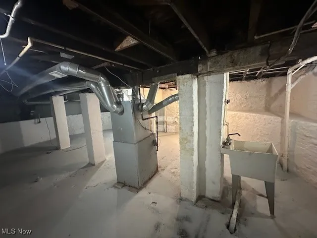 Unfinished below grade area featuring heating unit