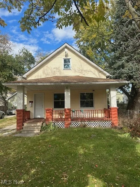 Bungalow-style house with a porch and a front lawn