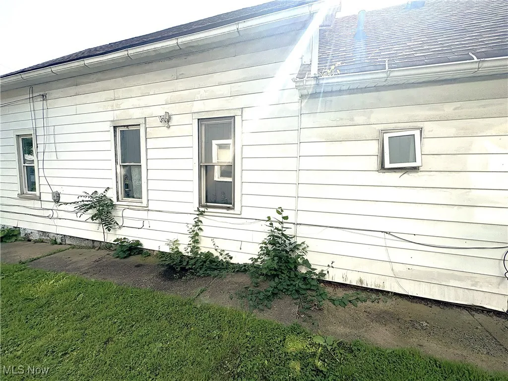 View of side of property featuring a lawn